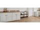The kitchen features a dark wood and metal shelving unit for storage, complementing the earth tone tile at 2251 Evenglow Ave, Spring Hill, FL 34609