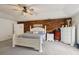 Large primary bedroom features a wood accent wall, tray ceiling, ceiling fan, and plush light gray carpet at 2251 Evenglow Ave, Spring Hill, FL 34609