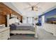 Large primary bedroom with wood accent wall, tray ceiling, light gray carpet, and a ceiling fan at 2251 Evenglow Ave, Spring Hill, FL 34609