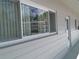 View of the building's exterior showcasing the windows, siding, and unit number 37, with a reflection of nearby buildings at 2261 Swedish Dr # 37, Clearwater, FL 33763