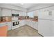 Bright kitchen featuring white appliances, neutral backsplash, and countertop with window for natural light at 2261 Swedish Dr # 37, Clearwater, FL 33763