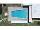 Aerial view of a rectangular community pool surrounded by lounge chairs and green space at 2261 Swedish Dr # 37, Clearwater, FL 33763