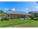 Landscaped backyard featuring a patio, lush lawn, and a charming residential building at 2275 Terrace View Ln, Spring Hill, FL 34606