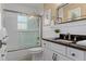 Well lit bathroom featuring white wainscoting and a modern vanity with dark stone countertop at 2275 Terrace View Ln, Spring Hill, FL 34606