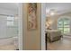 Transitional view of a bathroom leading to a bedroom with shuttered window and ceiling fan at 2275 Terrace View Ln, Spring Hill, FL 34606