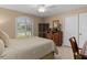 Bedroom with a golf course view from a shuttered window, wood furniture, and a neutral palette at 2275 Terrace View Ln, Spring Hill, FL 34606