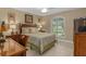 Bedroom with shuttered windows overlooking a golf course, and furnished with a beautiful wooden bed at 2275 Terrace View Ln, Spring Hill, FL 34606