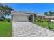 Well maintained single-story home featuring a paved driveway, lush lawn, and meticulously landscaped front yard at 2275 Terrace View Ln, Spring Hill, FL 34606