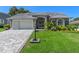 Well maintained single-story home featuring a paved driveway, lush lawn, and meticulously landscaped front yard at 2275 Terrace View Ln, Spring Hill, FL 34606