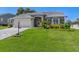 Well maintained single-story home featuring a paved driveway, lush lawn, and meticulously landscaped front yard at 2275 Terrace View Ln, Spring Hill, FL 34606