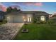 Charming single-story home featuring a paved driveway, lush lawn, and meticulously landscaped front yard at 2275 Terrace View Ln, Spring Hill, FL 34606