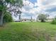 A large backyard shows the home with an in-ground swimming pool at 2414 San Luis Rd, Holiday, FL 34691