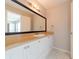 Bathroom with a white vanity cabinet, a large mirror, and neutral wall paint at 2414 San Luis Rd, Holiday, FL 34691