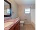 Bathroom with wood cabinets, granite counters, and tile flooring at 2414 San Luis Rd, Holiday, FL 34691