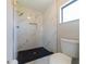 Modern bathroom with walk-in shower, marble-style tile walls, and black honeycomb floor tiles at 2414 San Luis Rd, Holiday, FL 34691