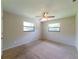Bedroom featuring two windows, neutral wall paint, a ceiling fan, and carpet flooring at 2414 San Luis Rd, Holiday, FL 34691