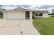 A single-story home features an attached garage, green lawn, and brick facade at 2414 San Luis Rd, Holiday, FL 34691