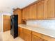 Spacious kitchen featuring honey colored wood cabinets, marble backsplash and black appliances at 2414 San Luis Rd, Holiday, FL 34691
