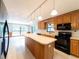 Bright kitchen with wood cabinets, center island, black appliances, and views to the backyard at 2414 San Luis Rd, Holiday, FL 34691