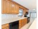 Bright kitchen with light wood cabinets, tile backsplash, stainless steel appliances, and a window over the sink at 2414 San Luis Rd, Holiday, FL 34691