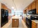 Spacious kitchen features wood cabinets, an island, and black appliances at 2414 San Luis Rd, Holiday, FL 34691