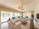 Bright living room featuring a ceiling fan, natural light, and sliding glass doors at 2414 San Luis Rd, Holiday, FL 34691