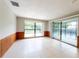 Open living room featuring tile floors, wood wainscoting, and views of the backyard and pool at 2414 San Luis Rd, Holiday, FL 34691