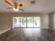 Bright living room features dark wood floors and large sliding doors to the lanai and pool area at 2414 San Luis Rd, Holiday, FL 34691