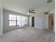Open bedroom with carpet floors, natural light from big window, and walk-in closet and ensuite access at 2414 San Luis Rd, Holiday, FL 34691