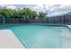 Backyard swimming pool surrounded by a fence and lush green landscaping at 2414 San Luis Rd, Holiday, FL 34691