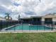 Home boasts a pool area surrounded by a safety fence and a spacious screened lanai at 2414 San Luis Rd, Holiday, FL 34691