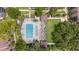 Aerial view of a community pool with landscaping, lounge chairs, a pergola, and green space at 2500 Winding Creek Blvd # G106, Clearwater, FL 33761