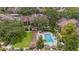 Aerial view of a community pool with lounge chairs, picnic tables, and pergolas at 2500 Winding Creek Blvd # G106, Clearwater, FL 33761