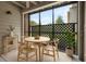 Cozy sunroom with a round table, four chairs, a plant, a rug, and a view of the exterior through large windows at 2500 Winding Creek Blvd # G106, Clearwater, FL 33761