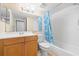 Bathroom with a wooden vanity and a shower-tub combo with blue shower curtain at 2500 Winding Creek Blvd # I106, Clearwater, FL 33761