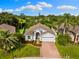 Aerial view of a beautiful home with mature landscaping, brick driveway, and a well-manicured lawn at 252 Arbor Woods Cir, Oldsmar, FL 34677
