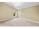 Carpeted bedroom featuring neutral walls, a ceiling fan, and a window overlooking the backyard at 252 Arbor Woods Cir, Oldsmar, FL 34677