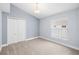 Bedroom featuring neutral carpet, light blue walls, a window, and a double-door closet at 252 Arbor Woods Cir, Oldsmar, FL 34677