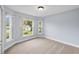 Bedroom featuring neutral carpet, light blue walls, and windows that bring in natural light and views of the outside at 252 Arbor Woods Cir, Oldsmar, FL 34677