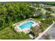 A sparkling community pool with ample lounging space, surrounded by palm trees and shaded areas at 252 Arbor Woods Cir, Oldsmar, FL 34677
