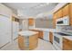 Bright kitchen with an island, white appliances and tile flooring at 252 Arbor Woods Cir, Oldsmar, FL 34677
