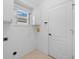 Bright laundry room featuring white cabinets, tile flooring and a window for natural light at 252 Arbor Woods Cir, Oldsmar, FL 34677