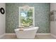 Charming bathroom with a freestanding tub, patterned wall, and natural light at 25487 Dan Brown Hill Rd, Brooksville, FL 34602