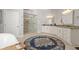 Elegant bathroom with a tiled glass shower, double vanity, granite countertops, and stylish round rug at 25487 Dan Brown Hill Rd, Brooksville, FL 34602