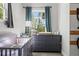 View of a Bedroom with a gray dresser, crib, and large window at 25487 Dan Brown Hill Rd, Brooksville, FL 34602