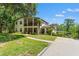 Charming two-story home featuring screened porches, a turret, beautiful landscaping, and a concrete driveway at 25487 Dan Brown Hill Rd, Brooksville, FL 34602