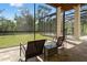 Covered patio featuring outdoor seating and views of the lawn, mature trees, and a fenced-in pool at 25487 Dan Brown Hill Rd, Brooksville, FL 34602