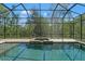 Screened-in pool area complete with a spacious paver deck, hot tub, and views of lush landscaping at 25487 Dan Brown Hill Rd, Brooksville, FL 34602