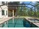 The screened in pool area featuring an attached hot tub, a large lounging area, and mature landscaping at 25487 Dan Brown Hill Rd, Brooksville, FL 34602