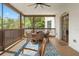 Inviting screened porch featuring an outdoor dining set and ceiling fan at 25487 Dan Brown Hill Rd, Brooksville, FL 34602